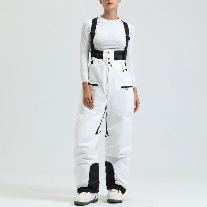 Model showcasing white snow trousers with black contrast knee patches and braces
