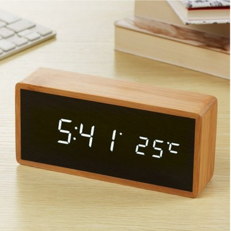 Digital wooden alarm clock with white LED display on a desk