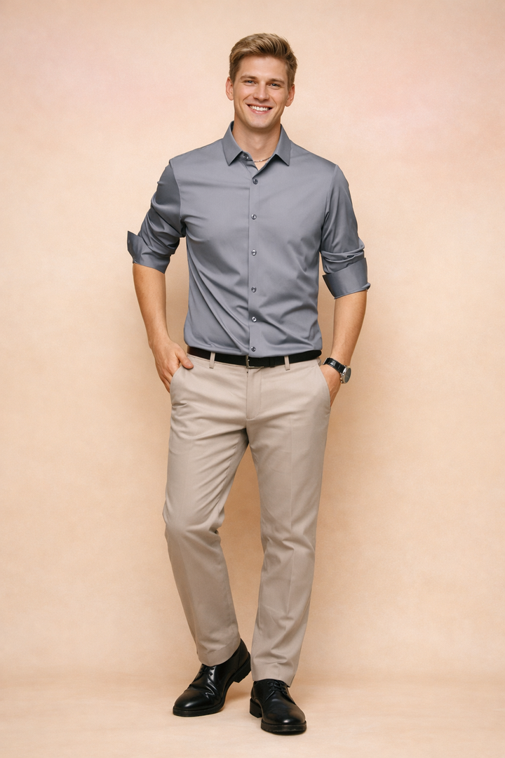 Man wearing a dark gray elegant button-down shirt paired with beige trousers in a studio setting