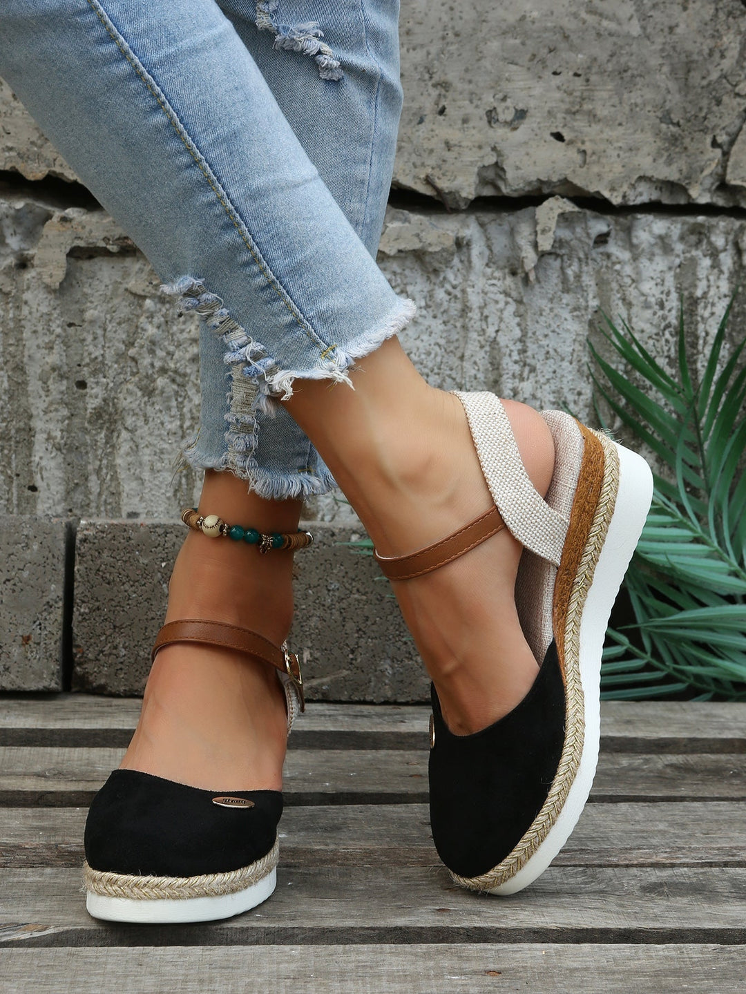 Close-up of black orthopedic espadrille wedge sandals styled outdoors