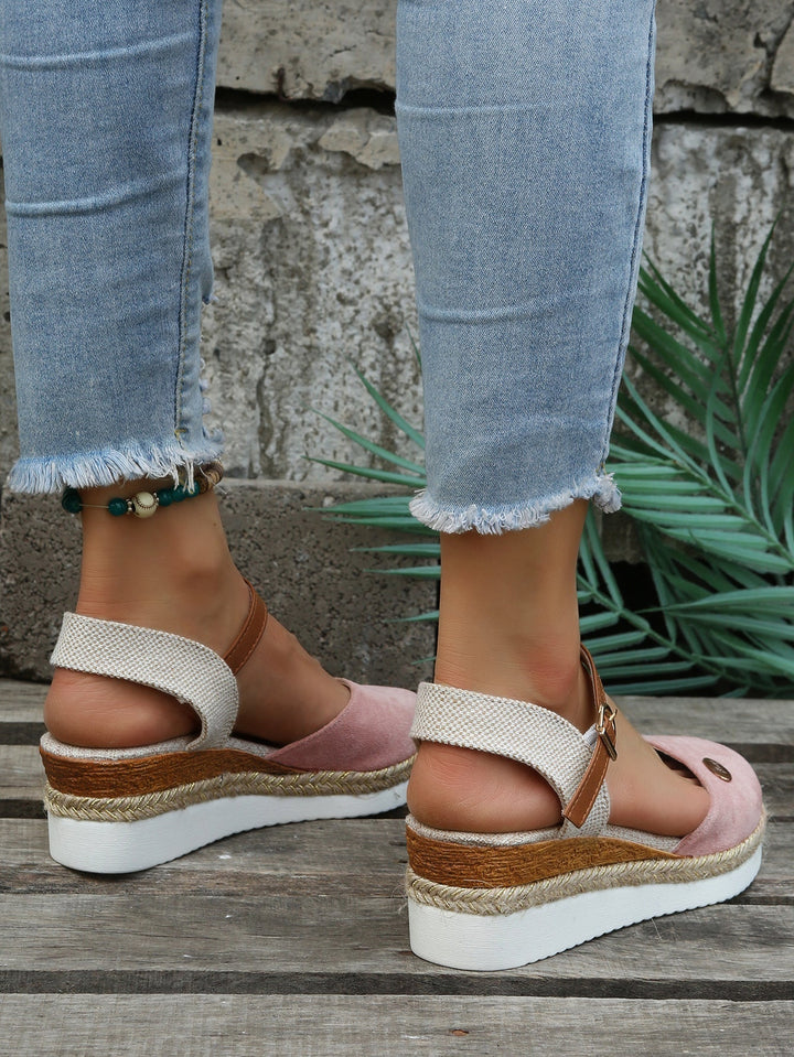 Close-up of pink orthopedic espadrille wedge sandals paired with light denim
