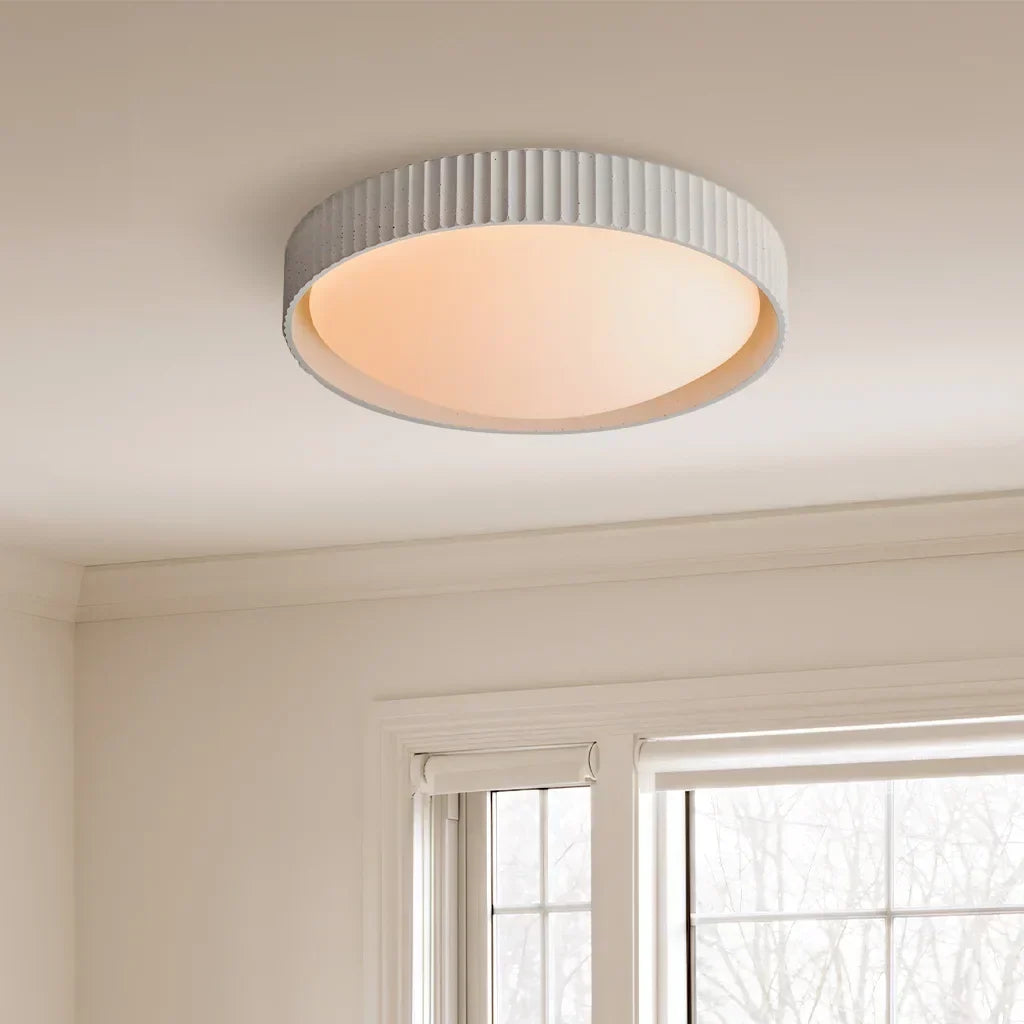 Side profile of the minimalist concrete flush mount light illuminating a hallway