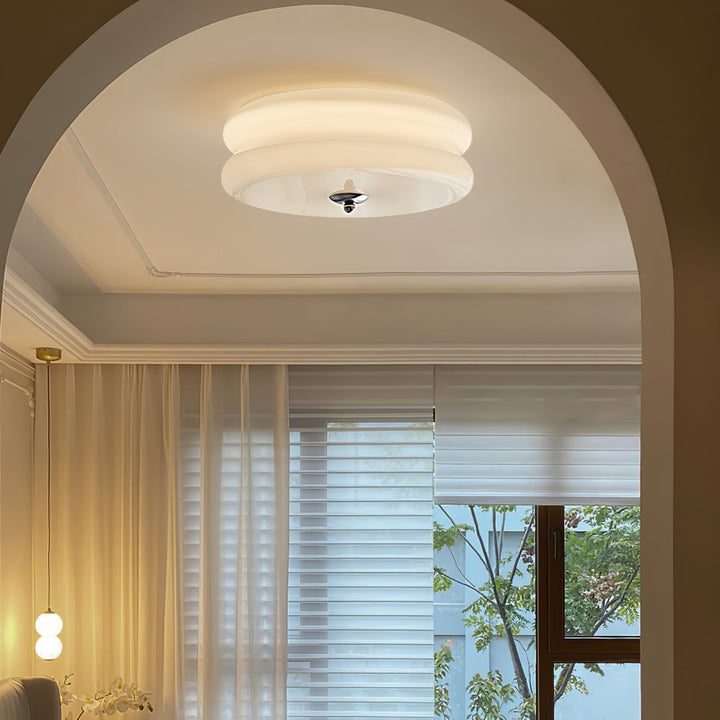 Illuminated Art Deco ceiling light installed in a modern hallway with arched doorway.