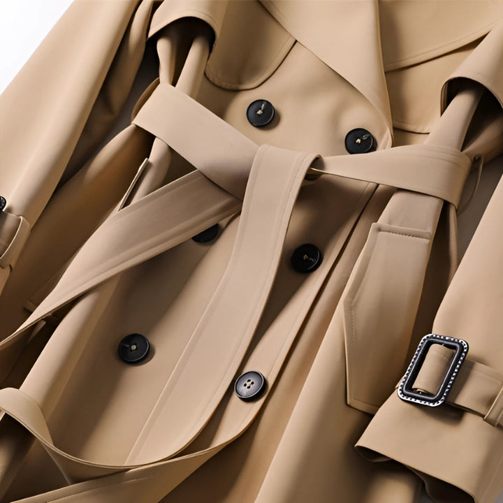 Close-up of buttons, belt buckle, and lapel details on trench coat