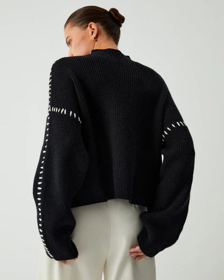Back view of a woman wearing a black knit pullover sweater