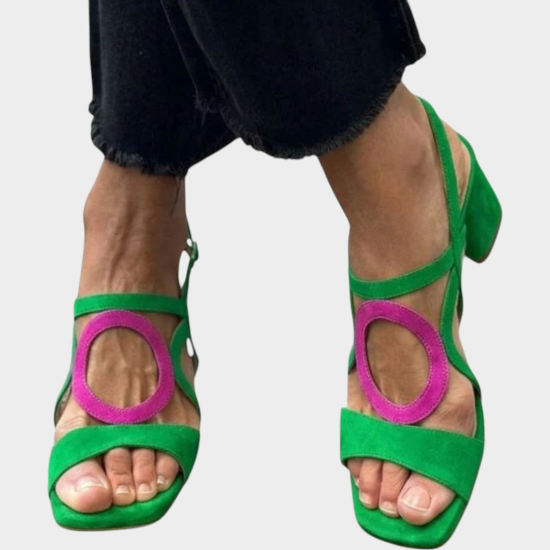 Green strappy block heel sandals worn with dark denim pants