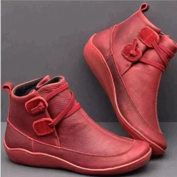 Pair of red women's orthopaedic ankle boots with decorative side straps