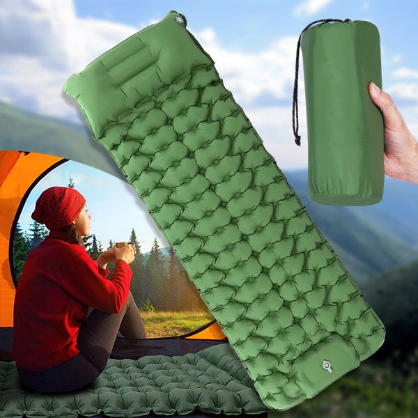 Green ultralight camping sleeping pad rolled out next to packed storage bag