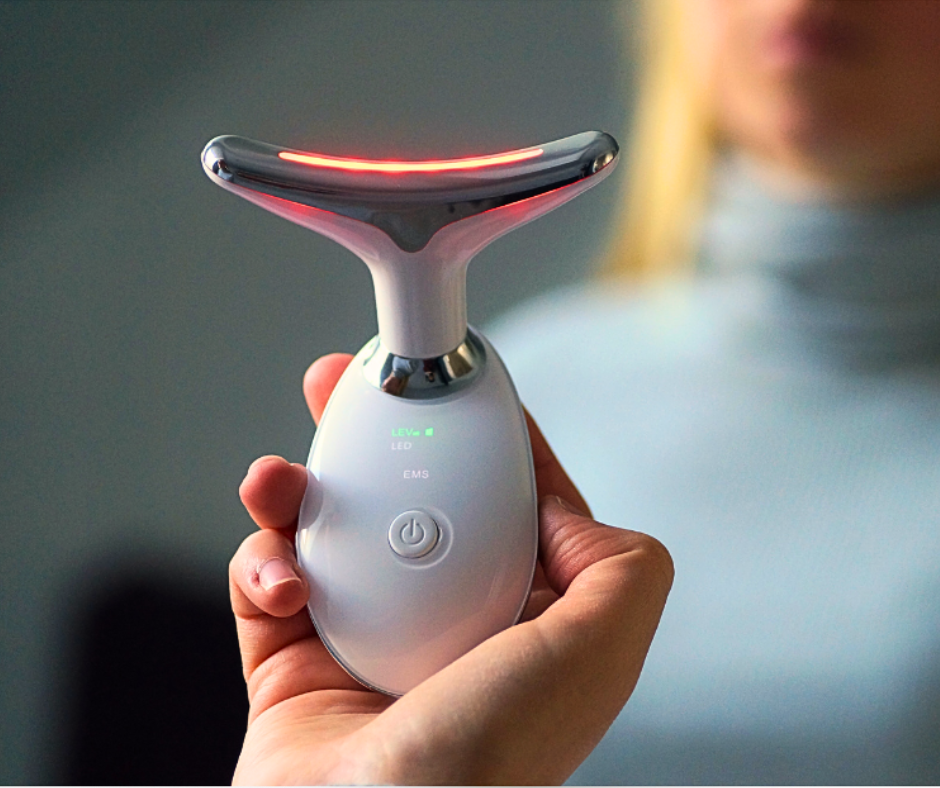 Person holding the white anti-aging facial device with red light therapy active