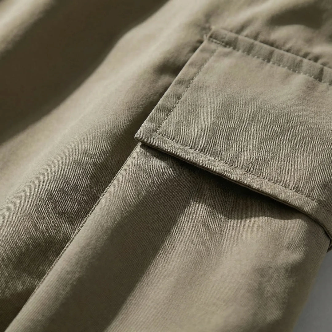 Close-up detail of the utility pocket on the green ski trousers