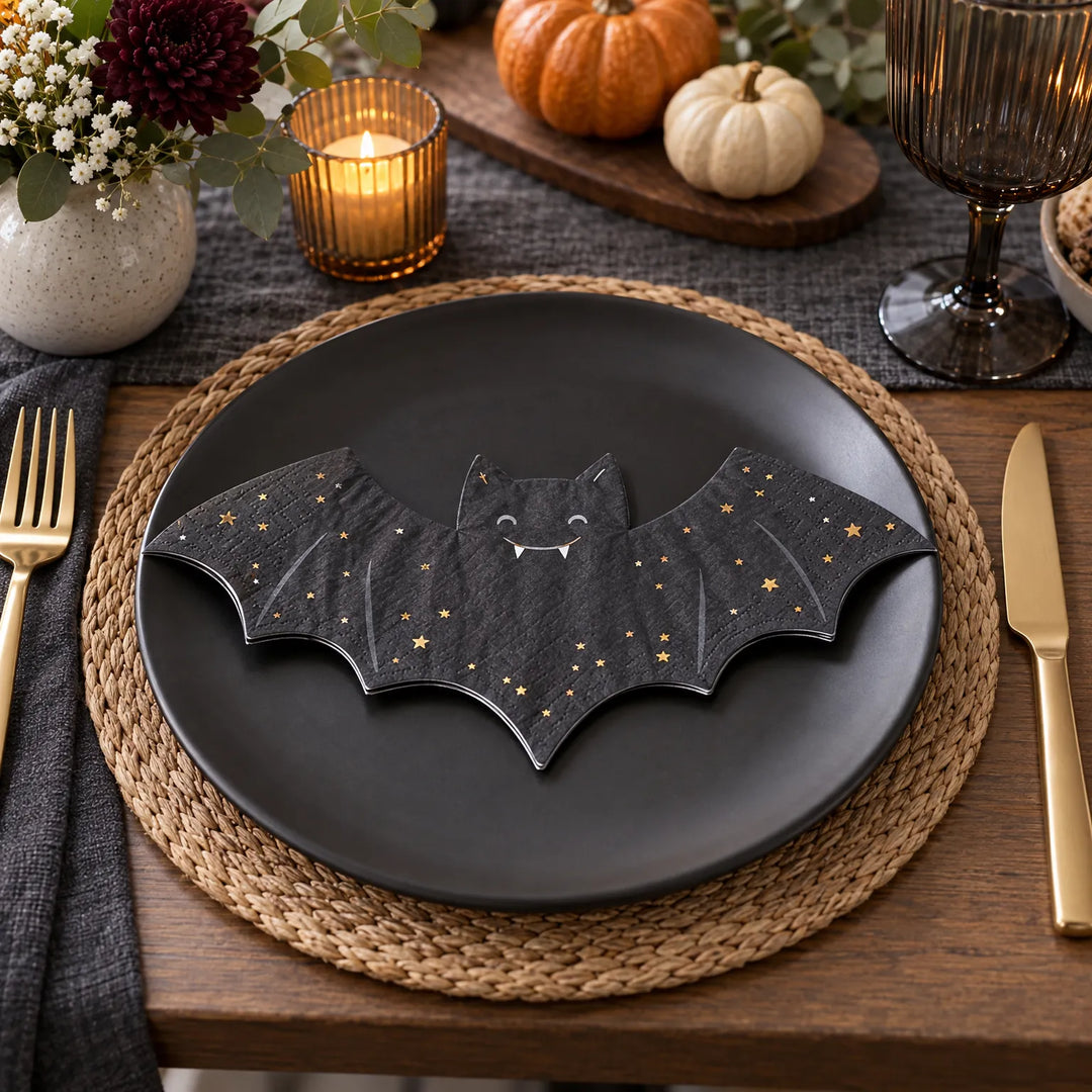 Black bat-shaped Halloween paper napkin displayed on a dinner plate