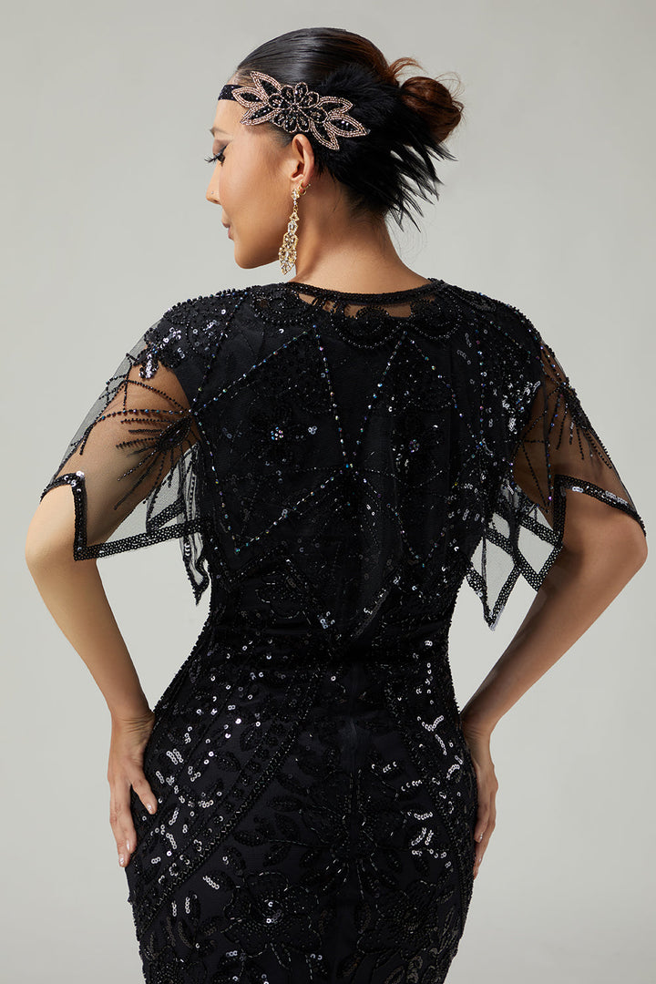 Back view of women's black sequin capelet showing draped mesh design