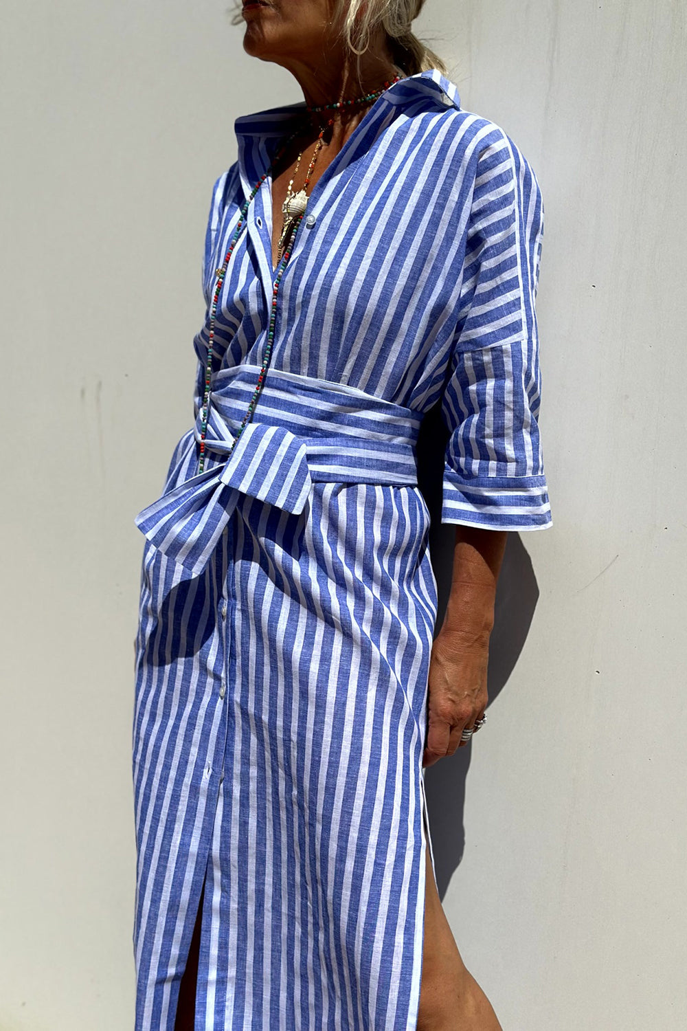 Side view of women's striped button-down midi dress for summer vacation fashion