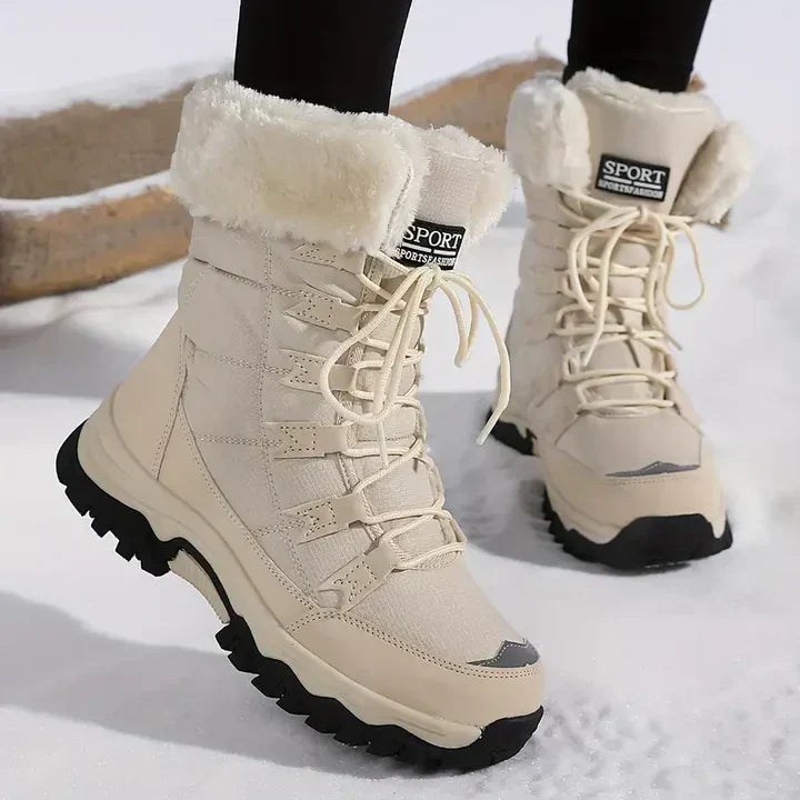 Beige women's winter snow boots with plush lining and lace-up closure standing in snow