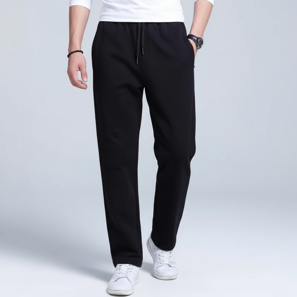 Full-length view of a man in black athletic joggers against a neutral background