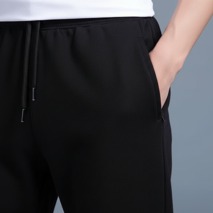 Close-up of the elastic waistband and pocket detail on black joggers