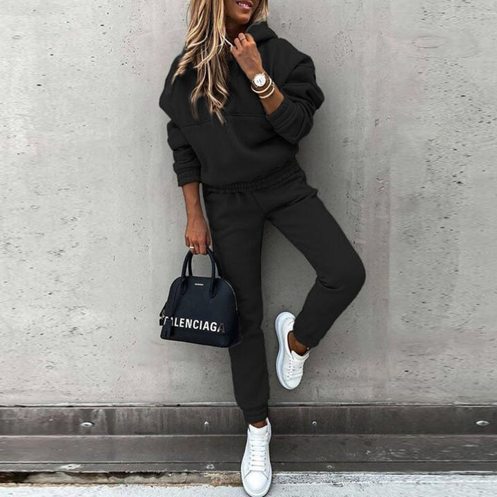 Woman posing in a comfortable black two-piece jogging set with stylish hooded top