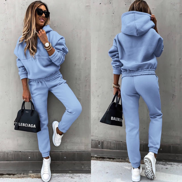 Woman wearing a soft blue jogging set with matching hoodie and trousers while posing outdoors
