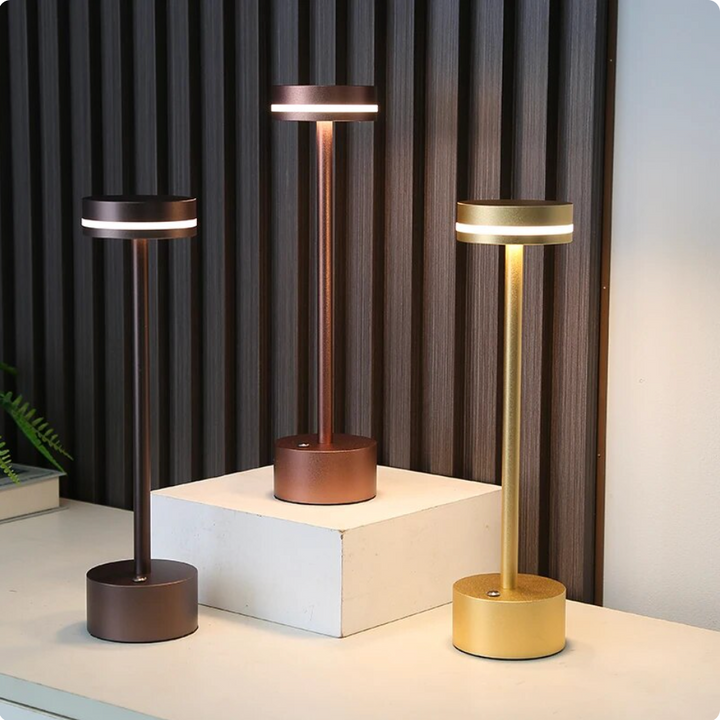 Solara cordless touch table lamps displayed in black, bronze, and gold finishes on a white surface.