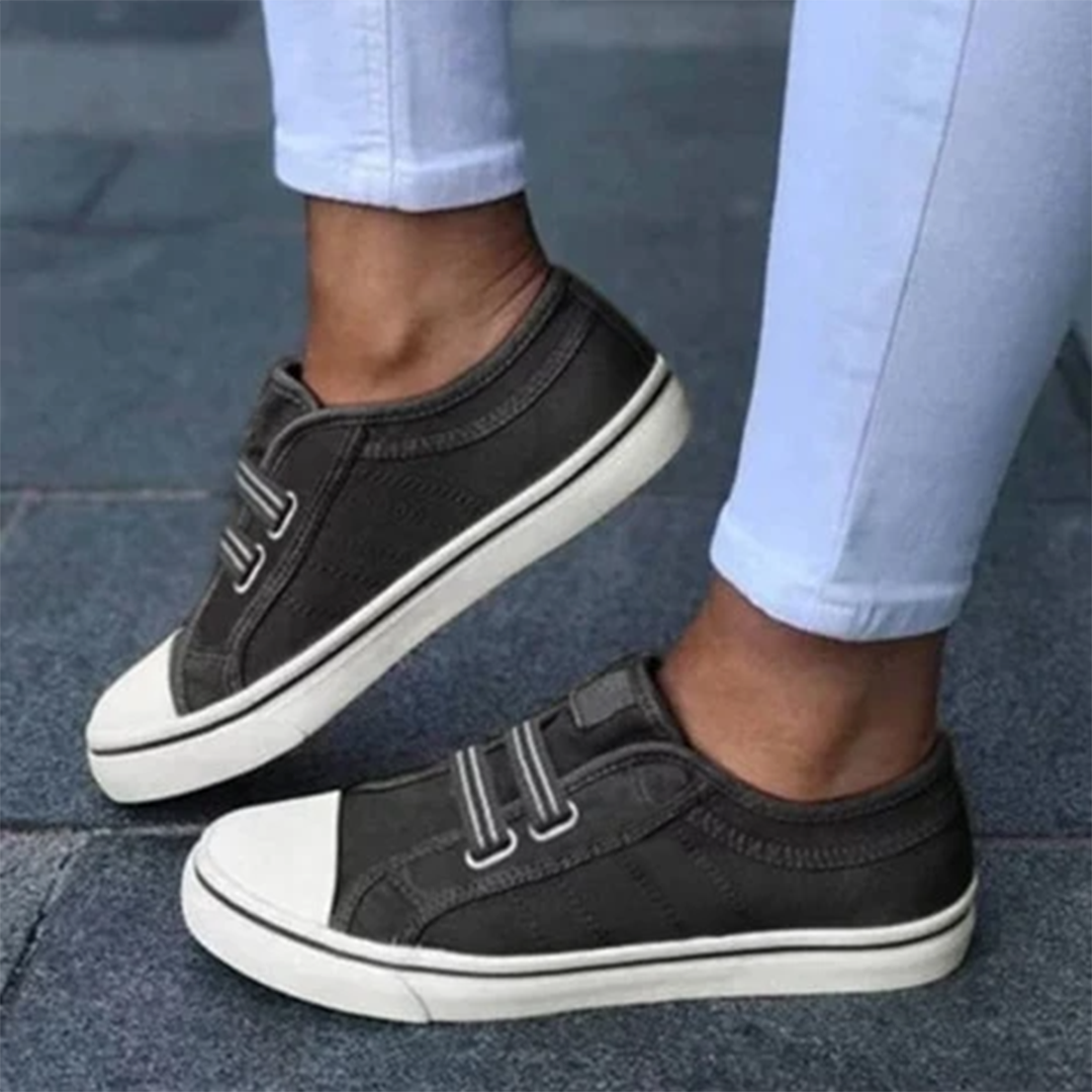 Dark grey women's slip-on sneakers paired with white pants