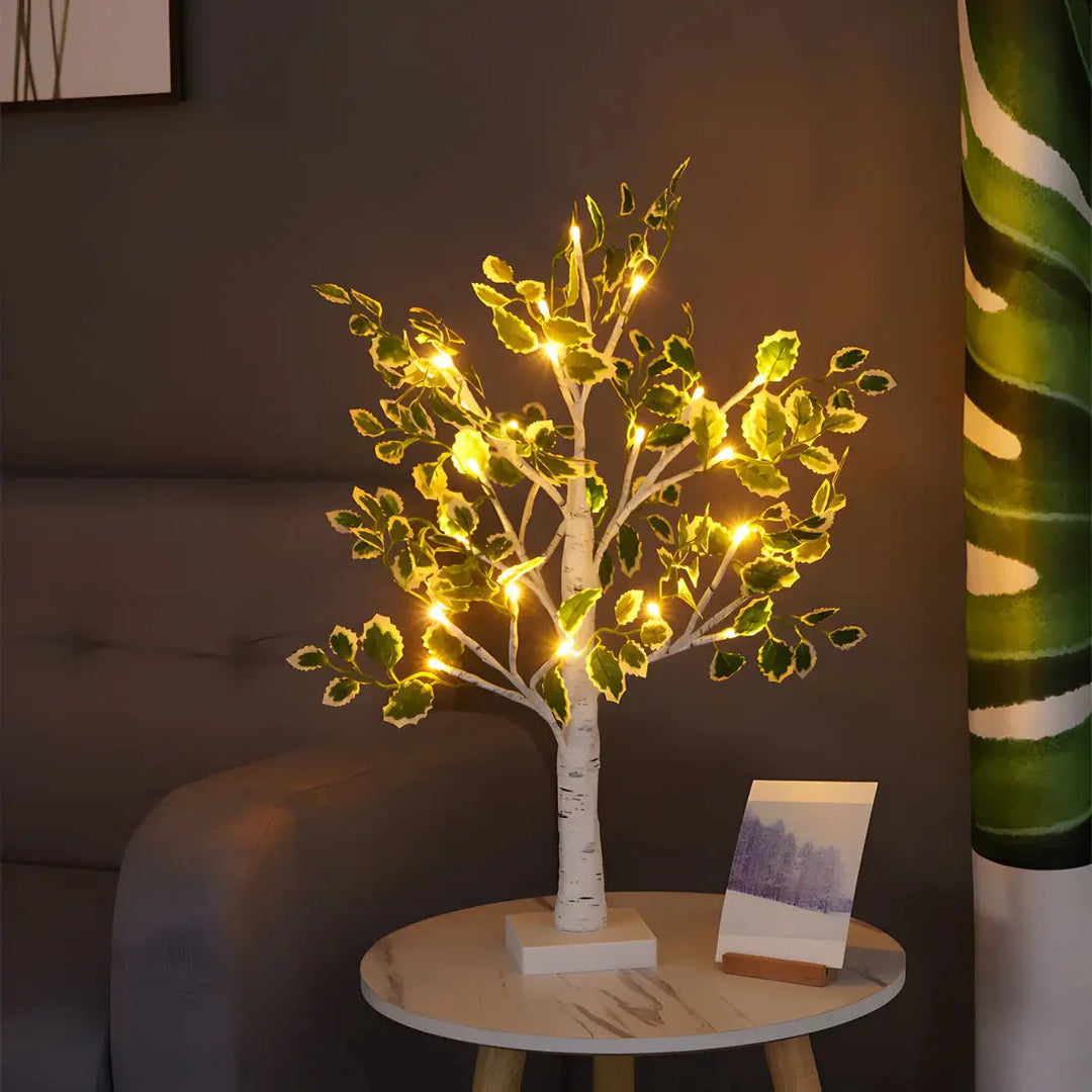 White glowing tree table lamp with warm LED lights in a bedroom setting
