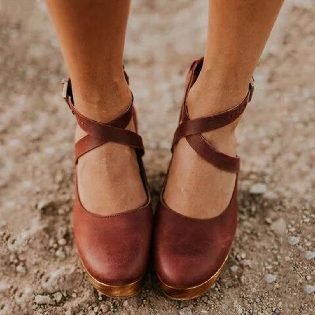 Close-up front view of brown wedge heels with adjustable ankle strap