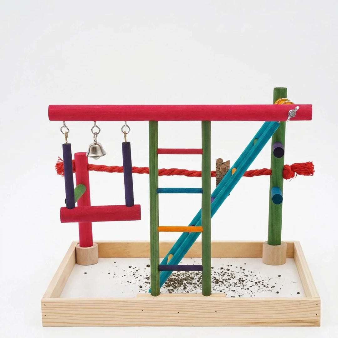 Colorful freestanding wooden bird playground with ladders and swing against a white background