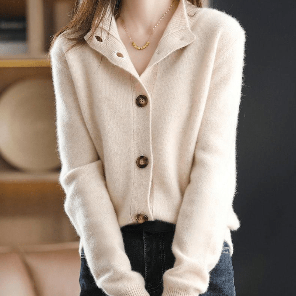 Close-up of beige knit cardigan with open collar and contrast buttons