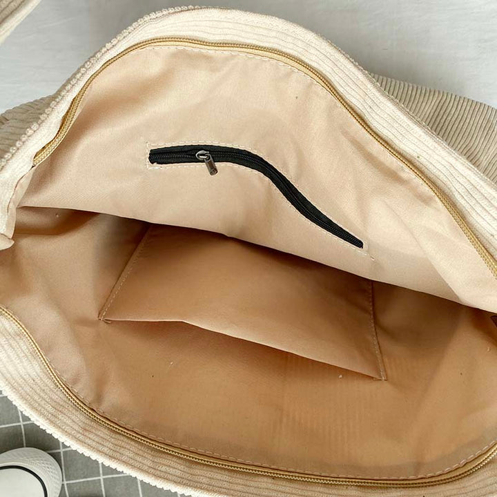 Open interior of white corduroy tote bag showing zipper pocket and lining