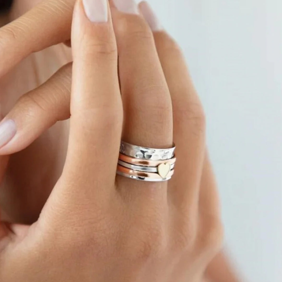 Detailed shot of the multi-band heart spinner ring worn on a finger