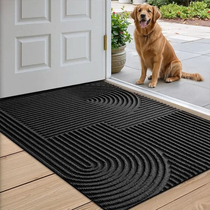 Golden retriever sitting next to the AQUARAY doormat by an open door