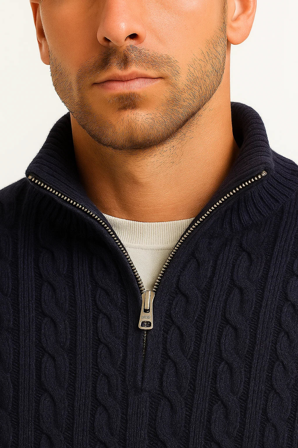 Close-up view of the metal zipper and collar detail on the dark blue cable knit jumper