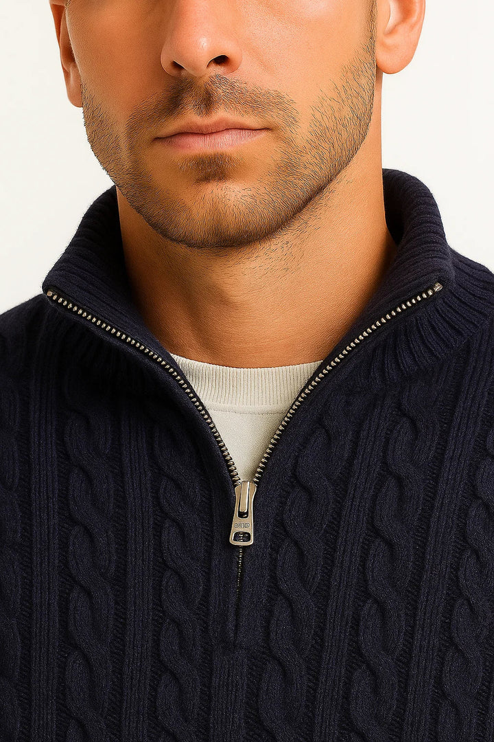 Close-up view of the metal zipper and collar detail on the dark blue cable knit jumper