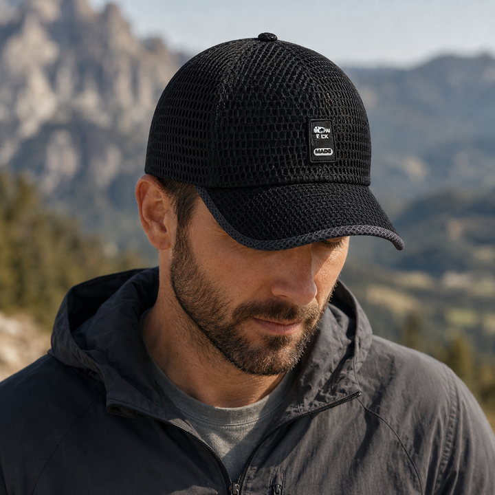 Man wearing black breathable mesh snapback baseball cap outdoors in nature