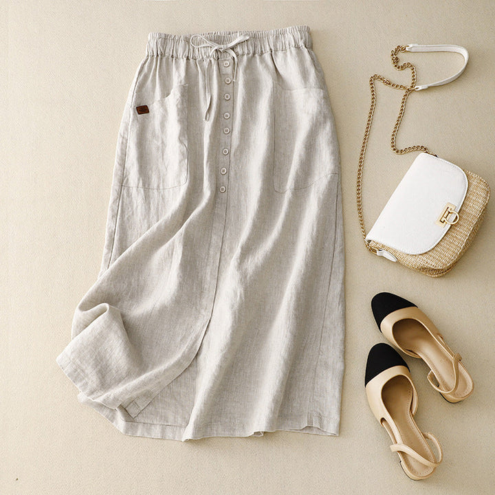 White casual midi skirt laid flat with matching designer handbag