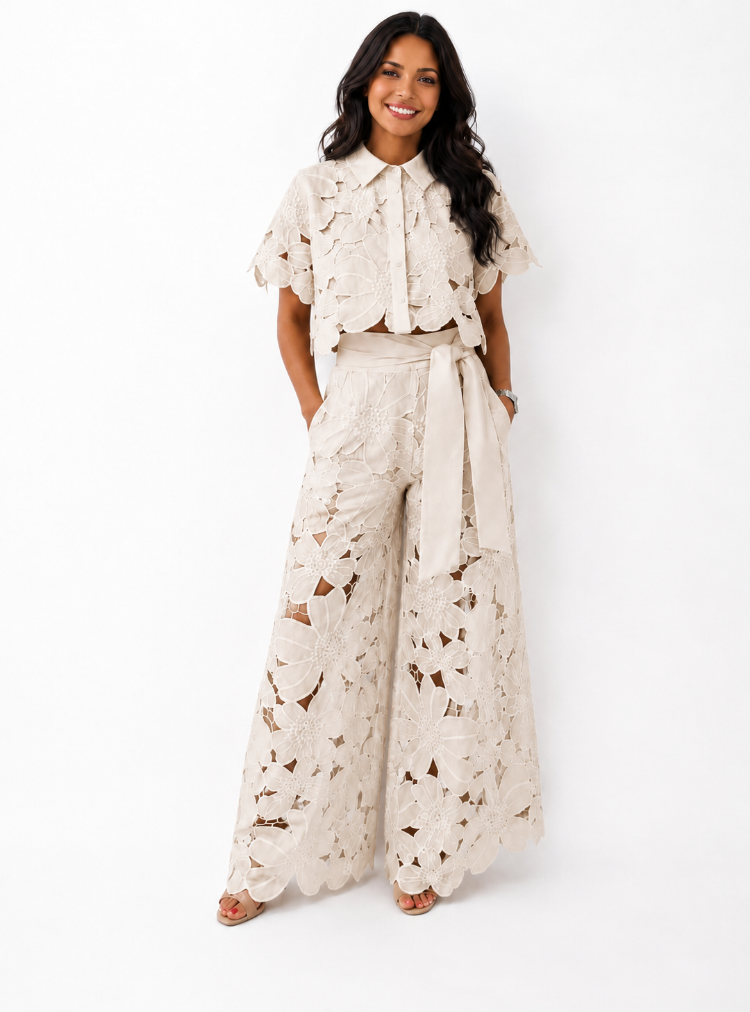 Woman wearing a beige floral lace two-piece crop top and wide-leg trousers set
