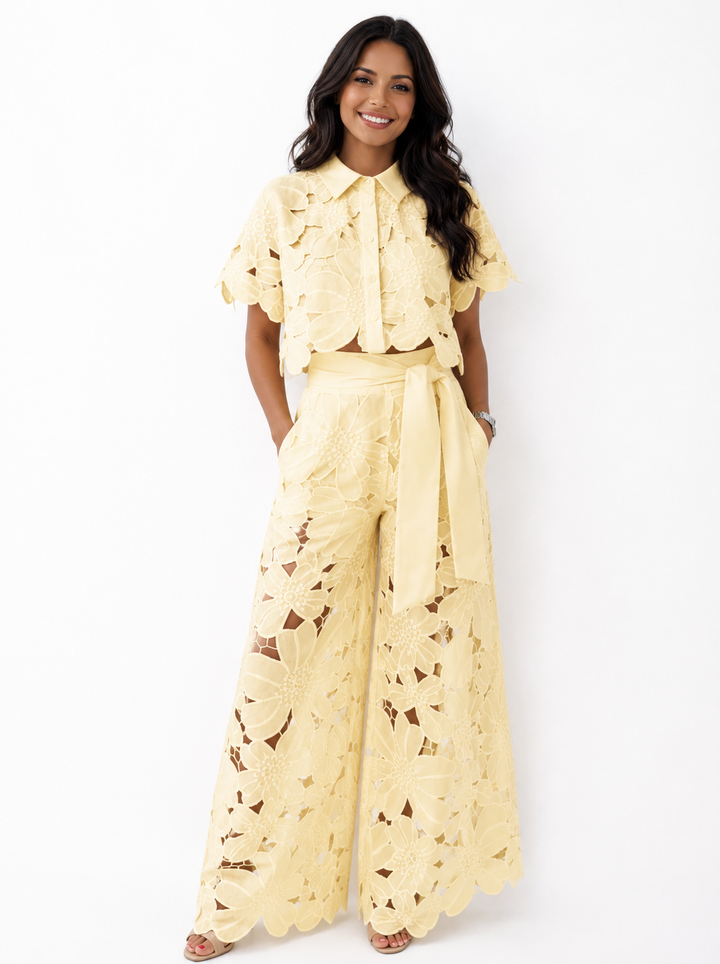 Woman wearing a yellow floral lace two-piece crop top and wide-leg trousers set