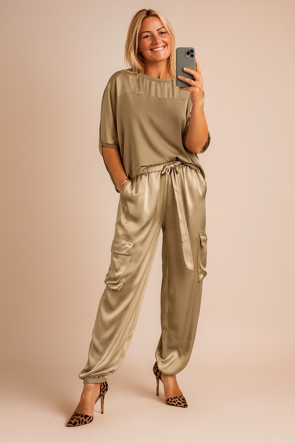 Woman wearing gold satin two-piece lounge set with matching top and trousers