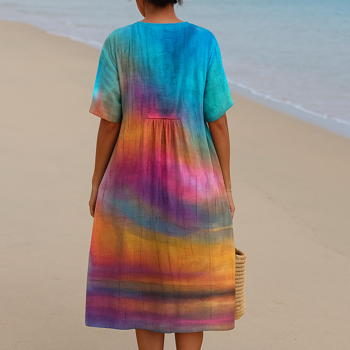 Back view of a woman wearing a colorful ombre tie-dye dress by the ocean