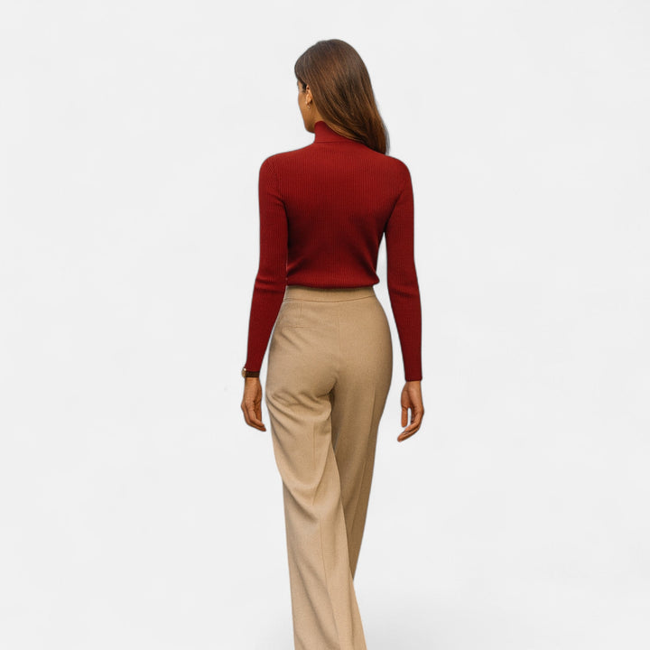 Back view of a woman wearing a red turtleneck sweater showcasing the slim fit silhouette