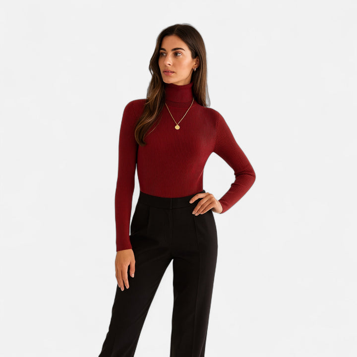 Model wearing a red slim fit long sleeve ribbed turtleneck sweater with black trousers