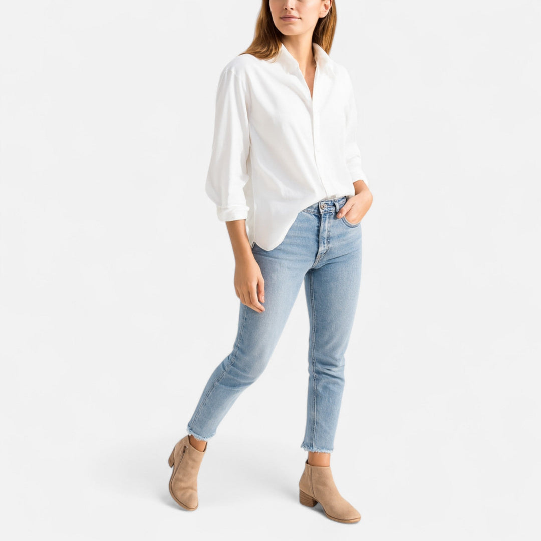 Full outfit view of a woman styling casual beige ankle boots with a white shirt and jeans