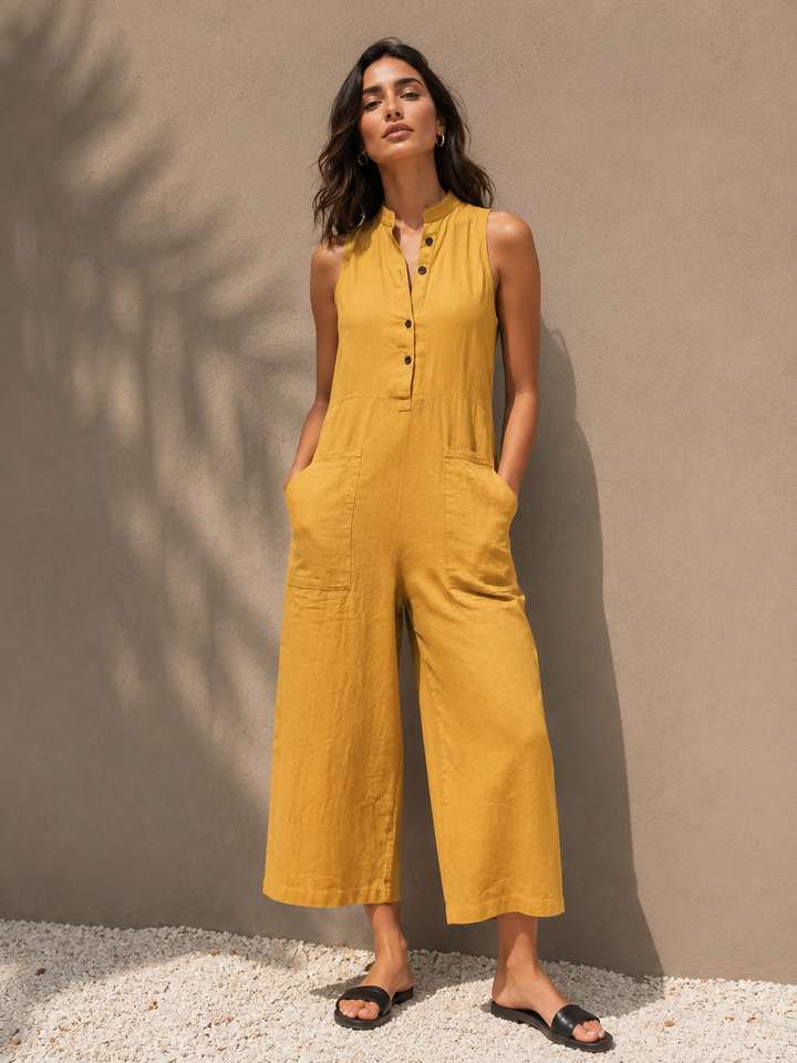 Woman wearing a yellow sleeveless wide leg jumpsuit with functional pockets