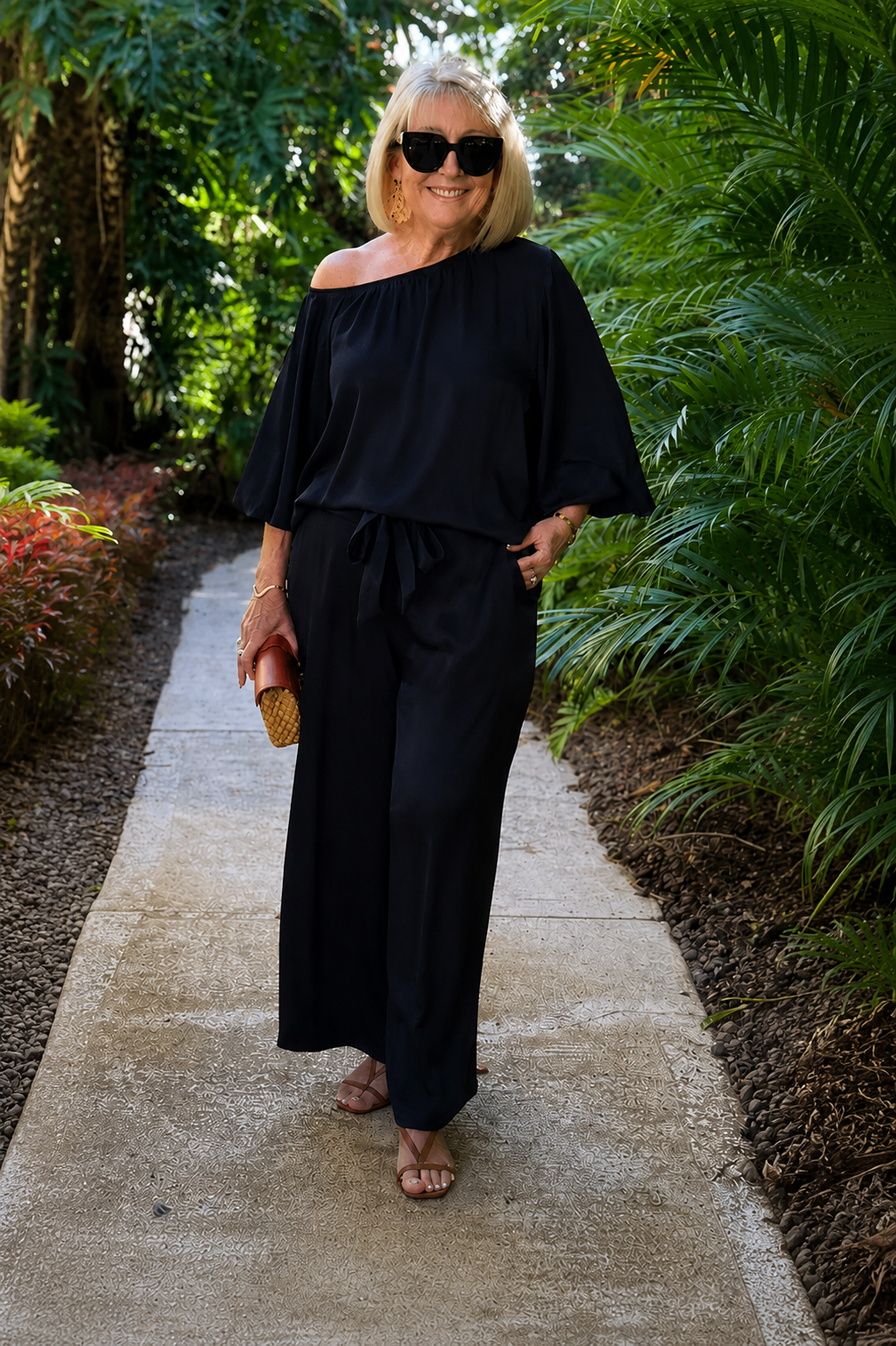 Woman wearing dark emerald green off-shoulder pant set outdoors