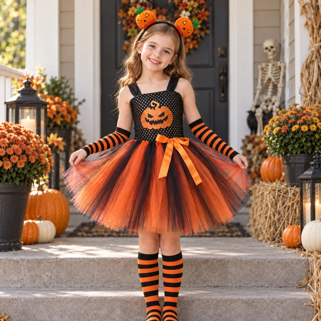 Young girl wearing a children's pumpkin Halloween costume with tutu skirt and accessories on a porch