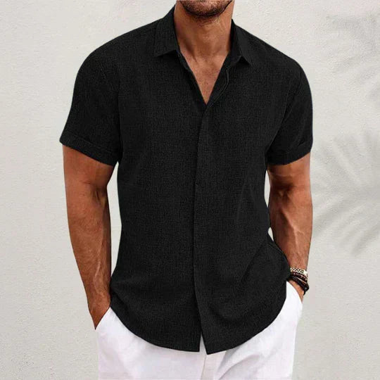 Man wearing a black short-sleeved casual button-up shirt with spread collar