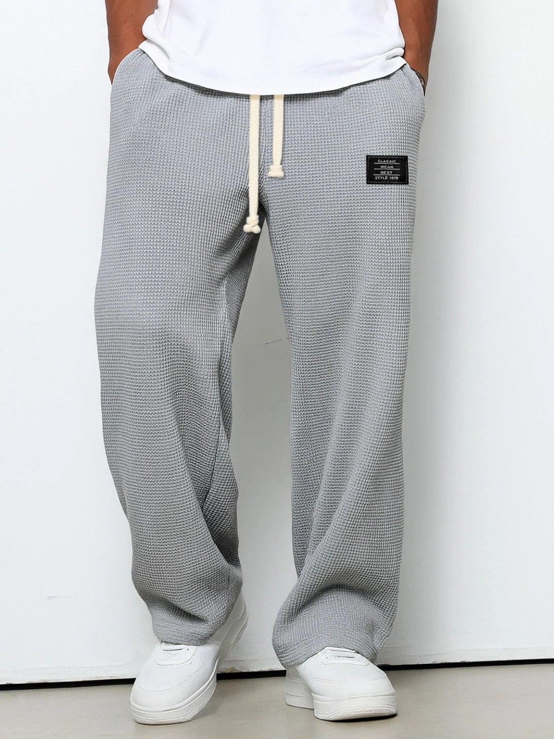 Man wearing grey relaxed fit trousers with front pockets
