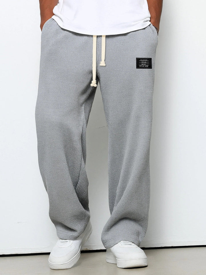 Man wearing grey relaxed fit trousers with front pockets