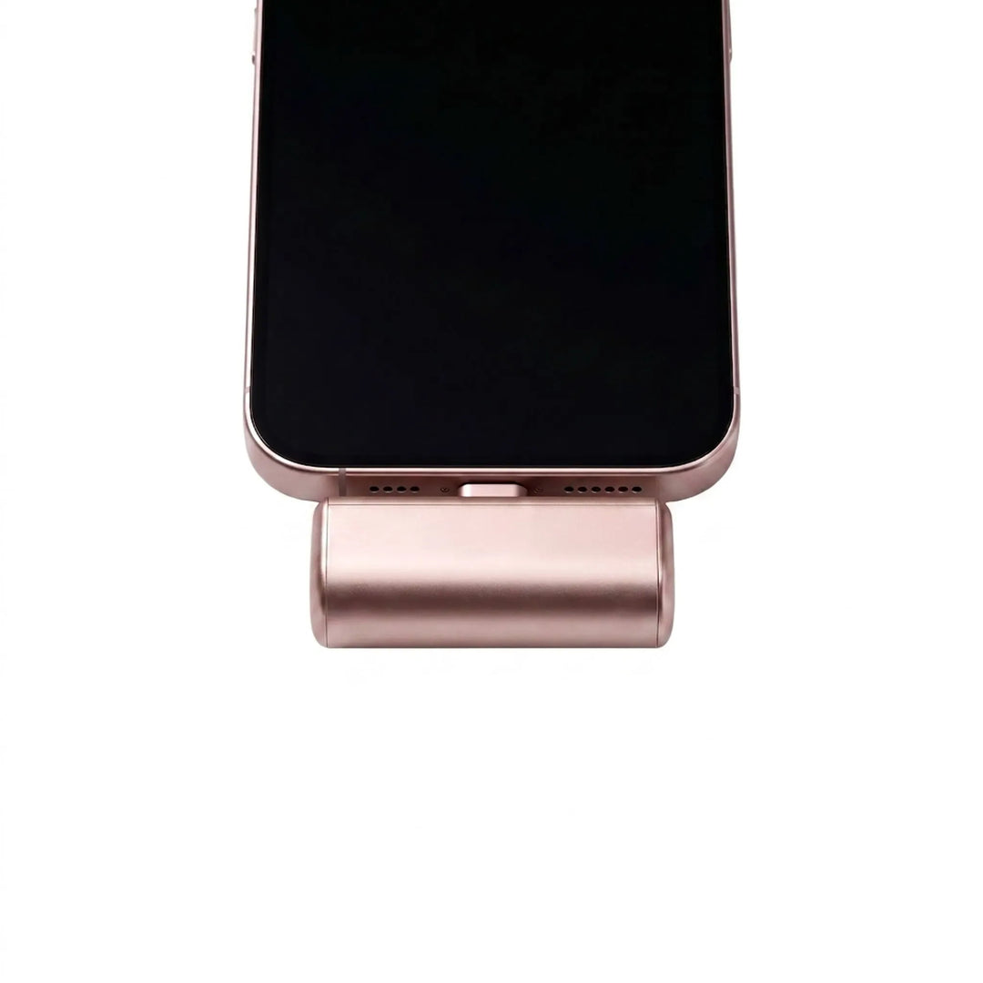 Close-up of a pink portable power bank connected to the bottom of an iPhone