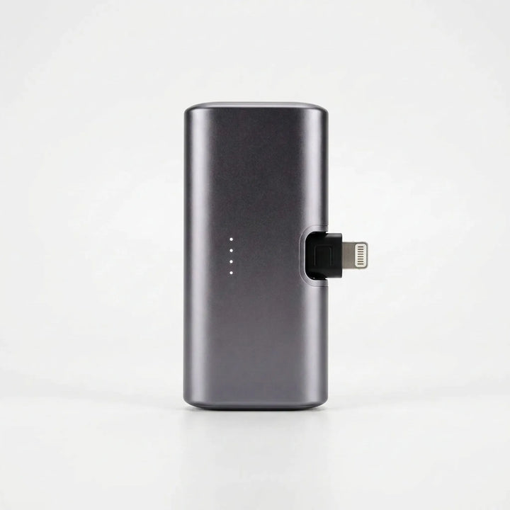 Portable charger with integrated plug showcased next to a modern smartphone